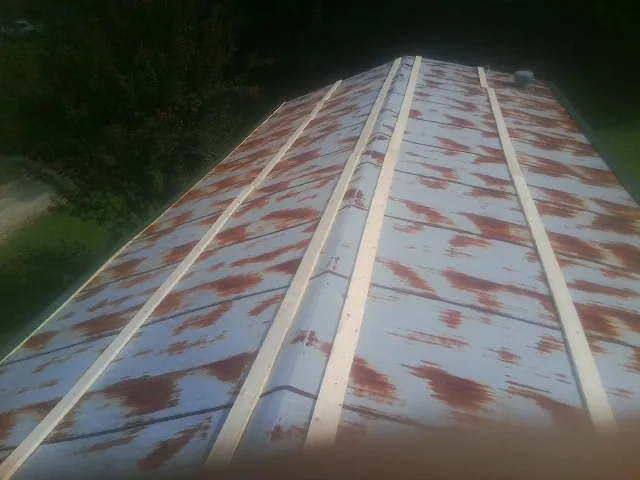 Rusted metal roof panels with new wood purlins before replacement — Storm Damage Roof Repair in Easthampton by Roofing Brothers