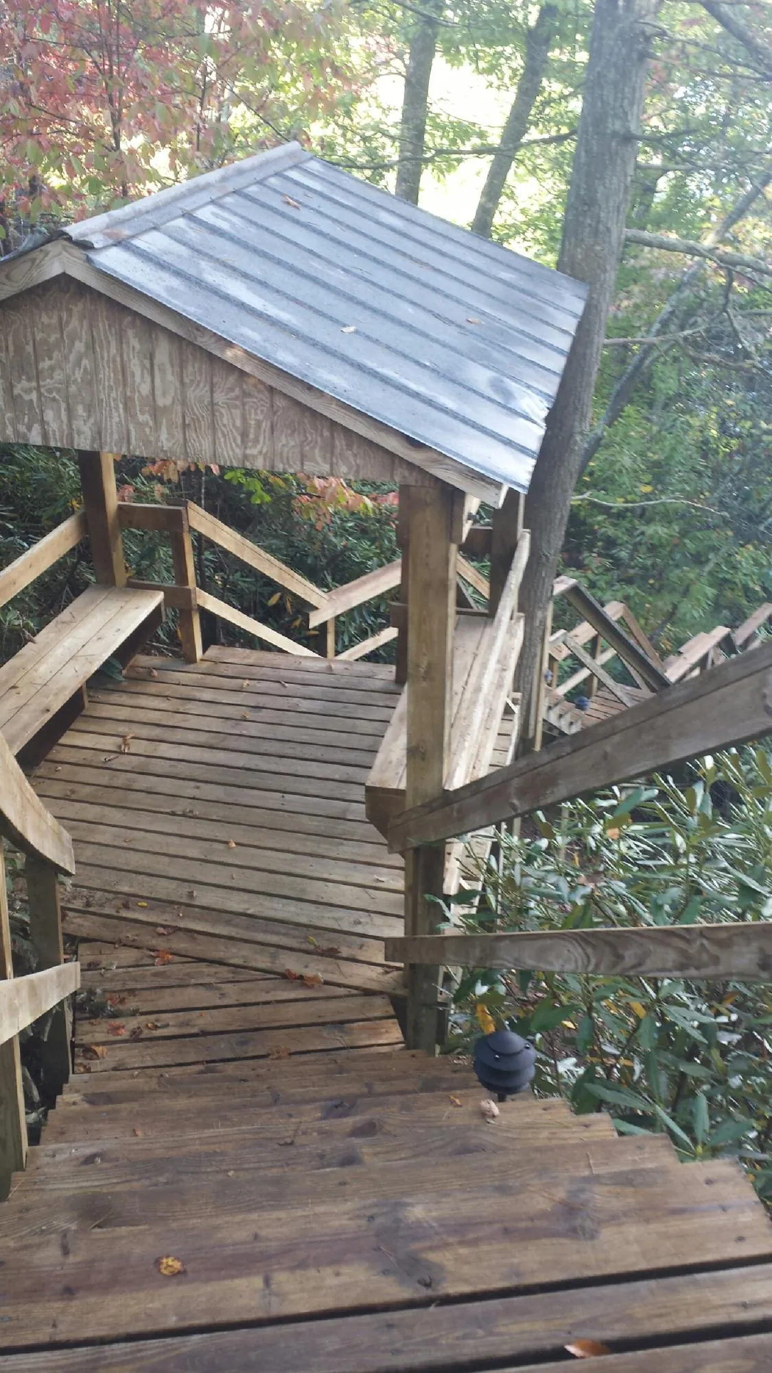 Metal roofed shelter over wooden steps on a wooded walkway — Skylight Repair & Installation work by our crew in Easthampton