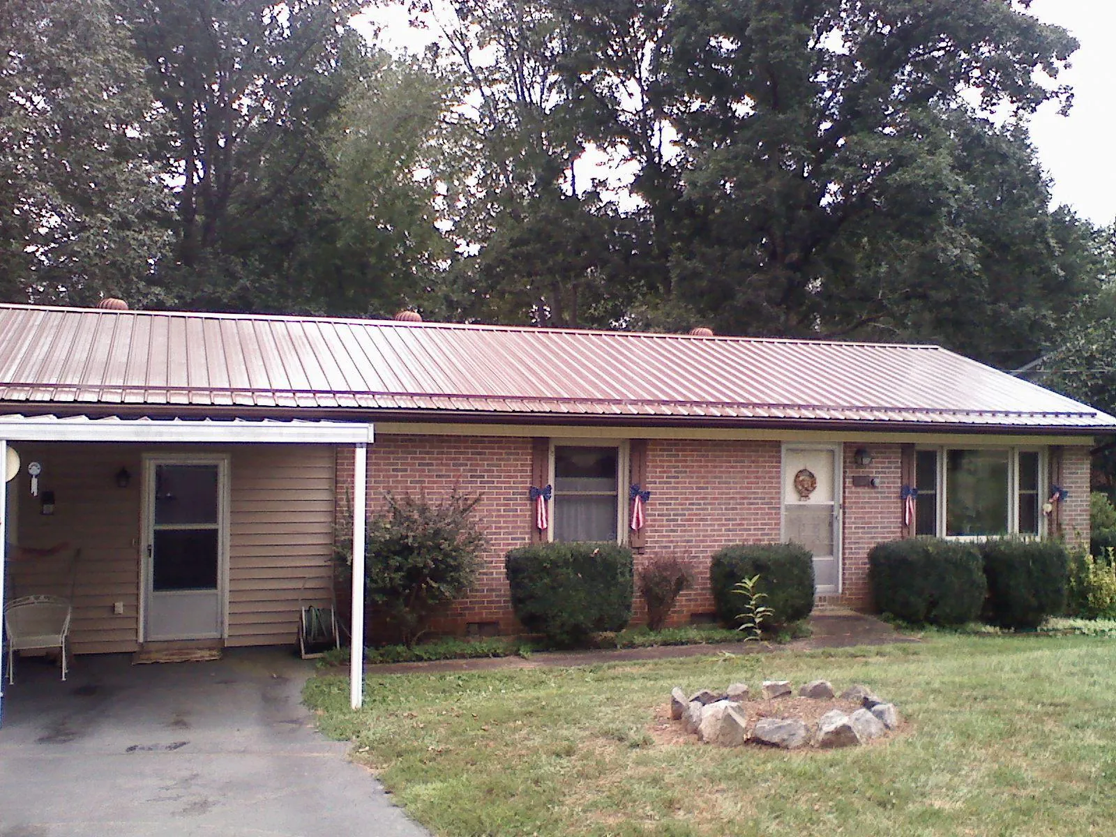 Bronze metal roof and carport on a brick ranch home — Roof Repair work by our crew in Easthampton